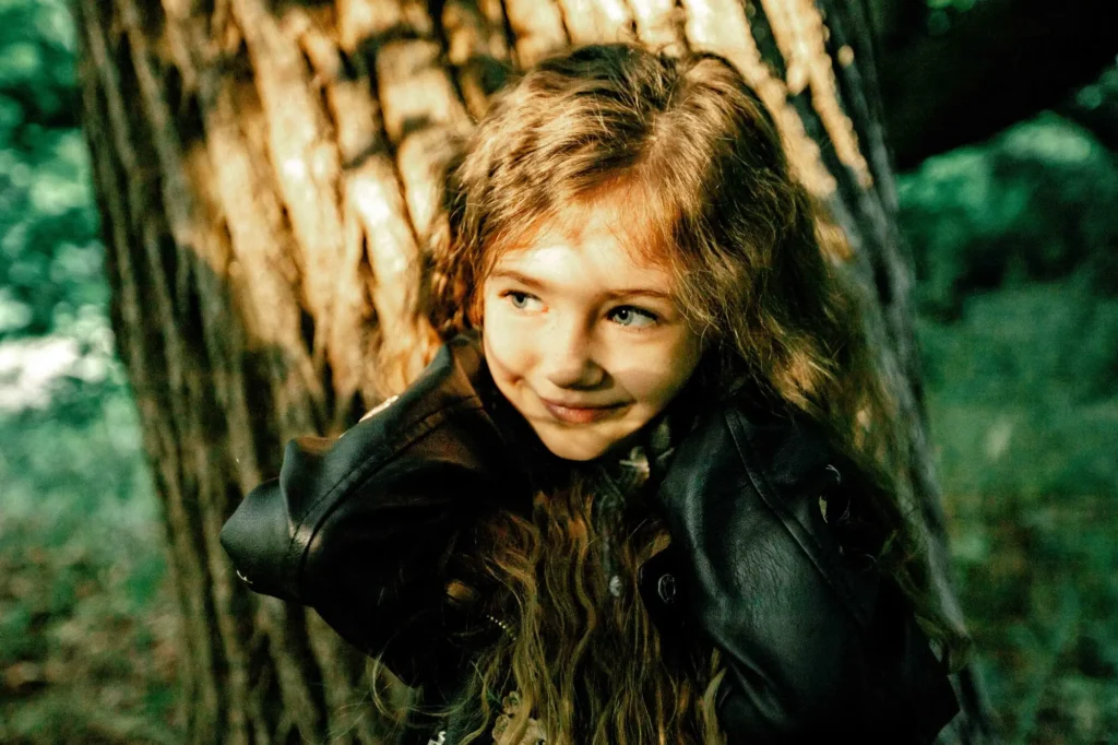 Candid portrait of a girl in a leather jacket smiling, Oxford children photographer at University Parks