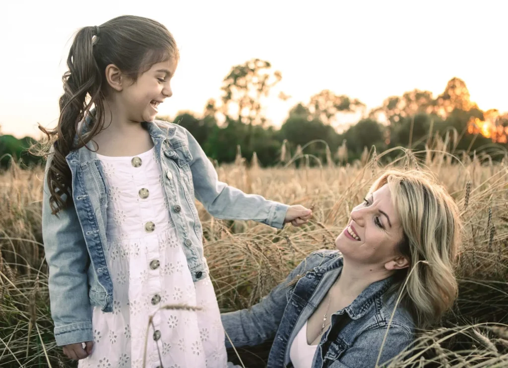 Mother and daughter laughing together at sunset in a wheat field, Oxford children photographer