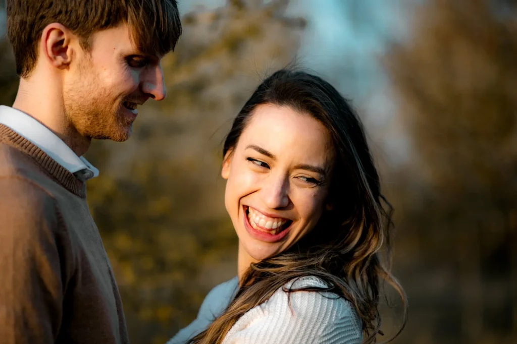 Candid close-up of a woman laughing over her partner's shoulder, Oxford engagement photography