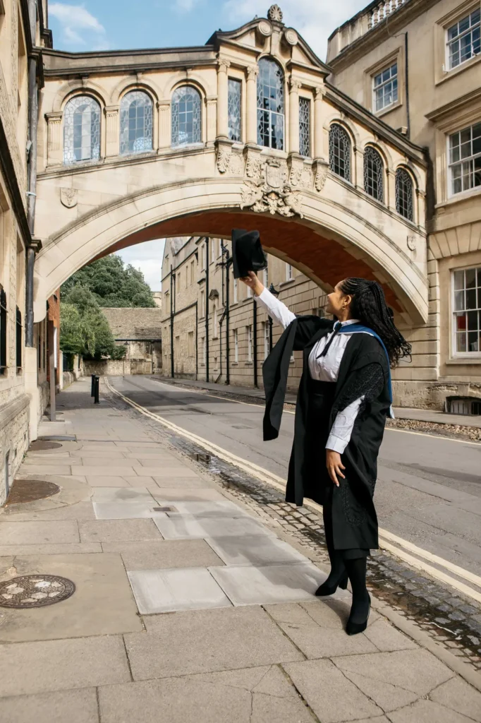 raduate joyfully raising her mortarboard beneath the Bridge of Sighs