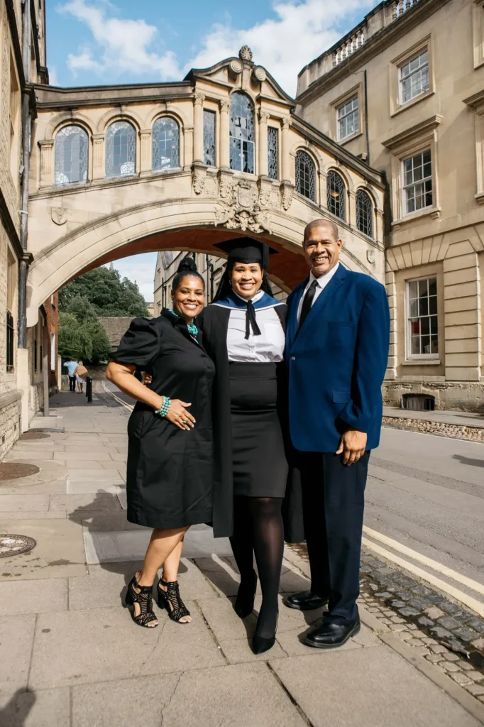 Graduate standing with her parents under Oxford's Bridge of Sighs on New College Lane