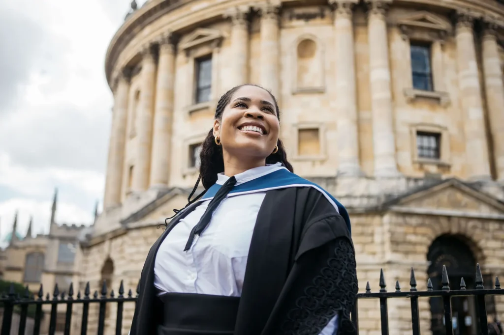Close-up portrait of a smiling graduate looking up outside the Radcliffe Camera