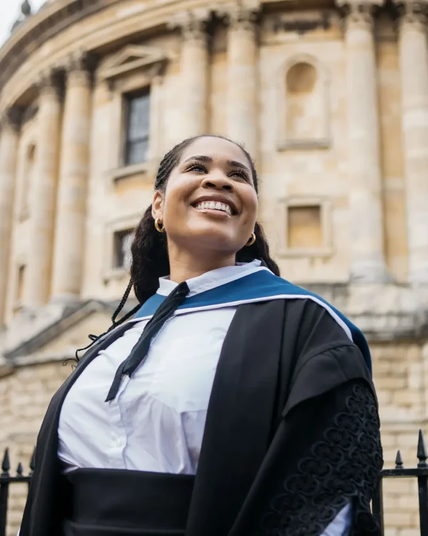 Close-up portrait of a smiling graduate looking up outside the Radcliffe Camera